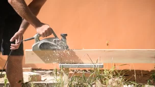 Charpentier plane une poutre avec plan en bois électrique — Video