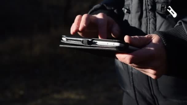 Volwassen man met behulp van Tablet PC in bos in de zomer — Stockvideo