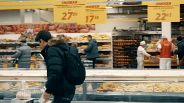 Adult man takes fish from the freezer in the supermarket — Stock Video