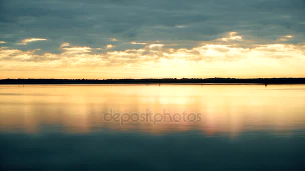 El lapso de tiempo de espléndidas nubes al amanecer sobre el agua — Vídeos de Stock