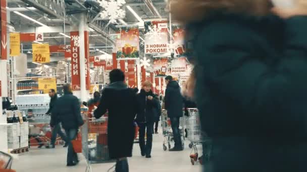 Muitas pessoas caminham no hipermercado Auchan — Vídeo de Stock