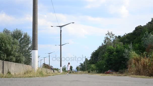 Hermosa chica adolescente montando un monopatín hacia la cámara — Vídeos de Stock