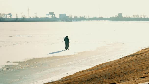Pescador caminha em um grande lago congelado . — Vídeo de Stock