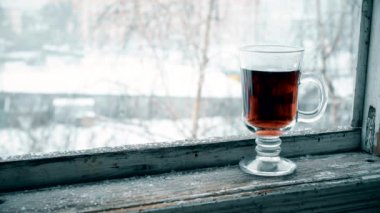 Cam bardakta çay pencere pervazına üzerinde düşen kar