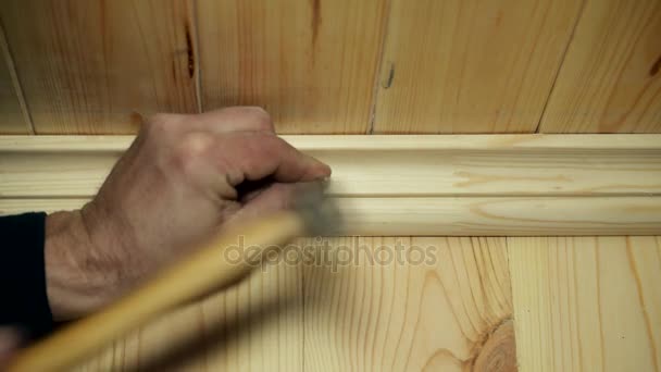 Male hands nailing a wooden skirting board — Stock Video