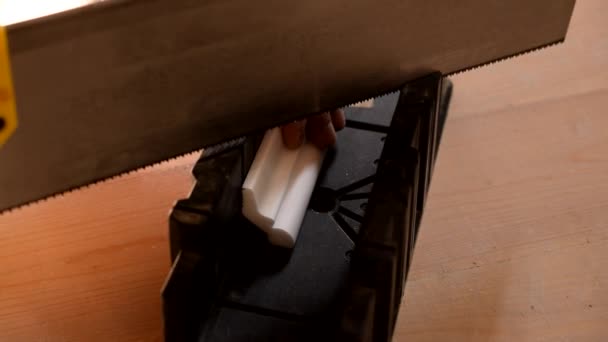 Manos de un artesano que corta una moldura de techo blanco — Vídeos de Stock