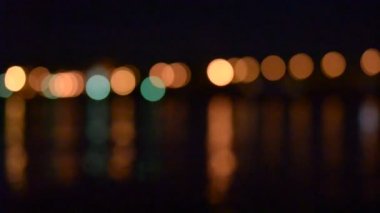 Şehir ışıkları su üzerinde odak haline gelip defocused