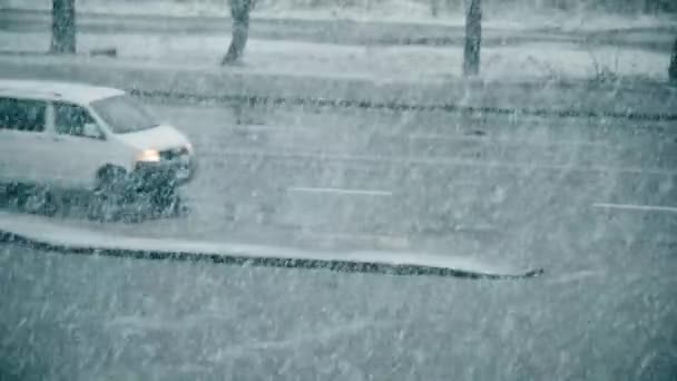 Slanting snow falling on background of blurred road — Stock Video