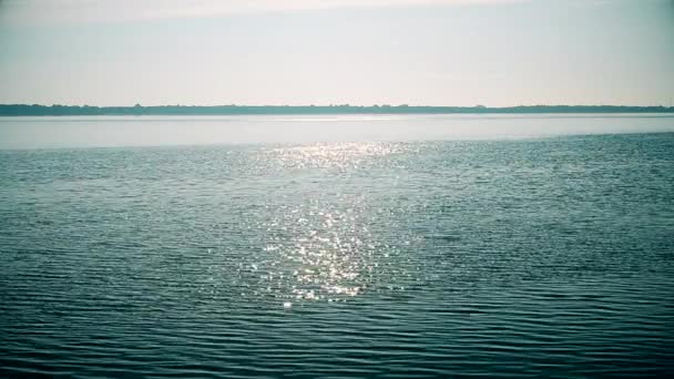 El sol brilla en la superficie del agua del río o lago — Vídeos de Stock