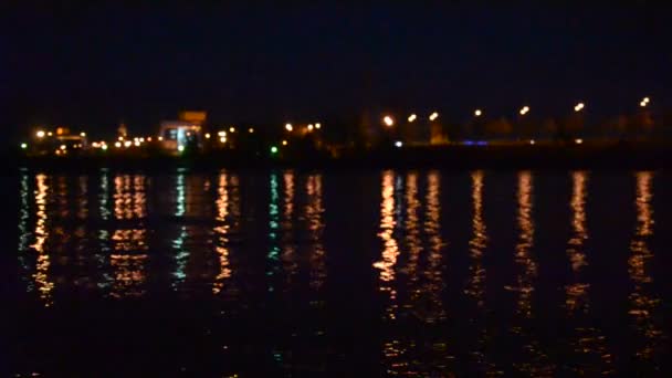 Paisaje urbano con luces de la ciudad reflejadas en el agua por la noche — Vídeos de Stock