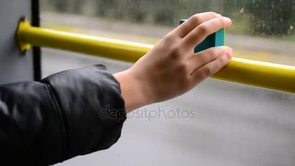 Hand of teenager holding an action camera near window in bus — Stock Video