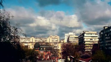 Zaman atlamalı köpüren ve çubuktaki şehir ile yüksek binaların üzerine bulutlar kaynar