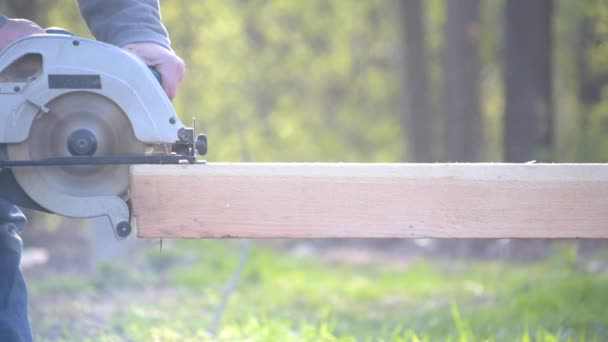 Sawing wooden beam with portable circular hand saw — Stock Video
