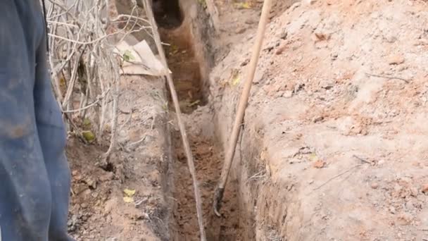 Man pouring water into trench with clayey soil — Stock Video