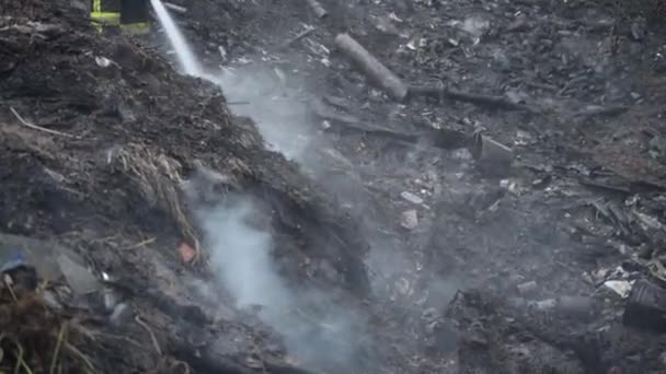 Fireman putting out a smoke from recent fire — Stock Video