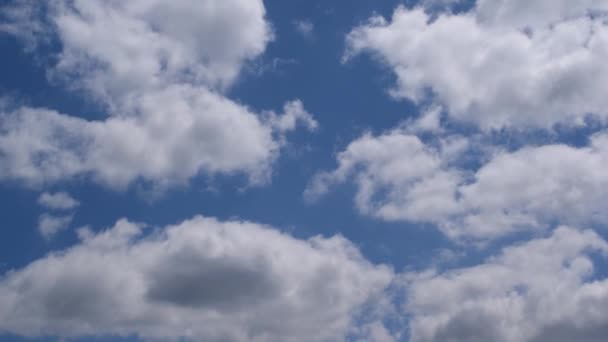 Белые и серые облака движутся в голубом небе — стоковое видео