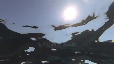 Küçük dalgalar ile bir güneş sualtı yavaş çekim