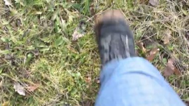 Kot pantolon ve çamurlu çizmeleri ayaklarda yeşil çimenlerin üzerinde yürüyüş