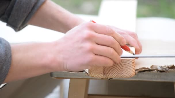 Markering van een houten balk met een potlood buitenshuis voor snijden — Stockvideo