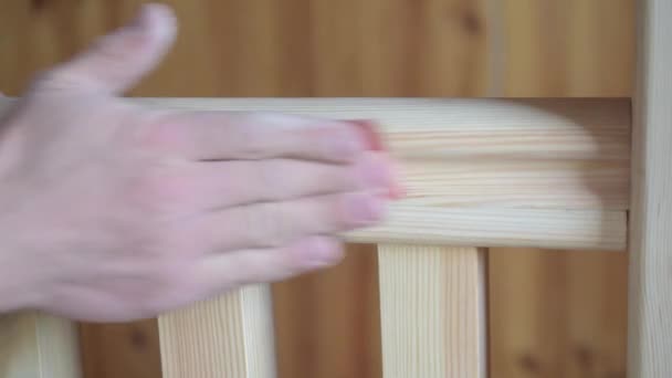 Manos del hombre puliendo pasamanos de madera con papel de lija — Vídeo de stock