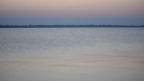 Kalm wateroppervlak van een meer of rivier in de schemering met kleurrijke sky — Stockvideo