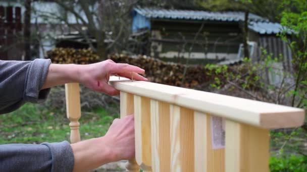 Rękach stolarza mocowania balustrady drewno sosnowe do deski — Wideo stockowe