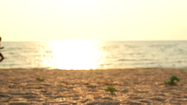 Mann läuft im Morgengrauen in Zeitlupe am Strand — Stockvideo