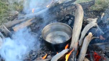 Şenlik ateşi üzerinde metal bir tencerede su kadar Isınma