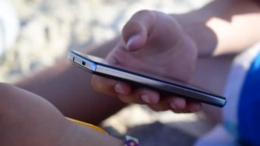 Kumsalda hareket eden smartphone kullanarak eller