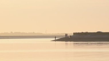 Anglers balıkçılık çubuklar ile şafak
