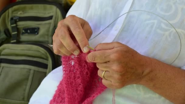 Hands of an elderly woman knitting red wool — Stock Video