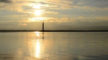 Şafakta deniz feneri arka plan üzerinde kuş uçar