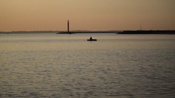 Silhouette di uomo fila in una barca sull'acqua — Video Stock