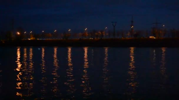 Şehir ışıkları ile kentsel gece manzarası suya yansıyan — Stok video