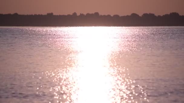 Luz do sol refletida na água do lago ou rio formando um caminho do sol ou caminho da luz na água — Vídeo de Stock