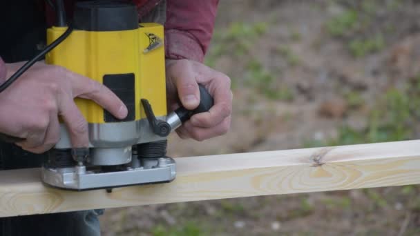 Hände, die mit einem Tauchfräser an einer Holzplanke arbeiten — Stockvideo