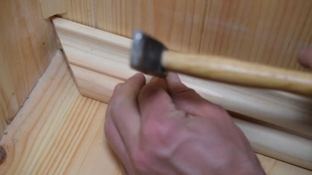 Mains d'un homme apposant une plinthe en bois — Video