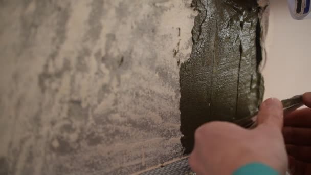 As mãos do funcionário de telha que cola telhas quadradas a uma parede — Vídeo de Stock