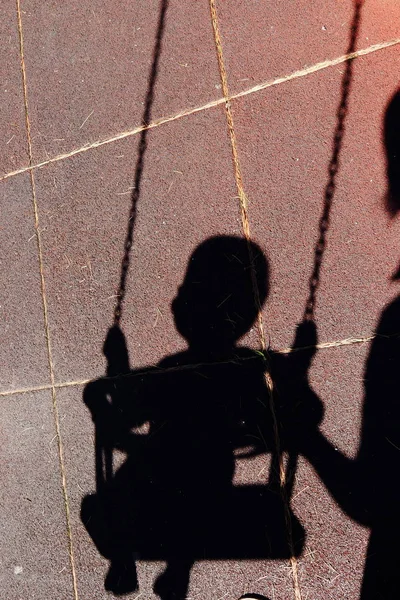 bir çocuk bir salıncak üzerinde gölgesi