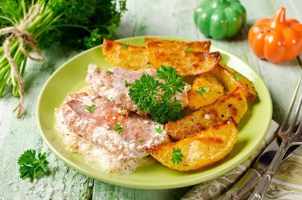 Chuletas de cerdo con crema agria y patatas al horno —  Fotos de Stock