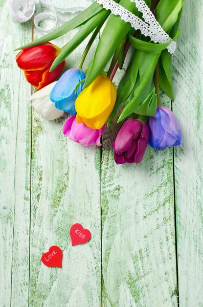 Multicolored tulips on a shabby green table — Stock Photo, Image