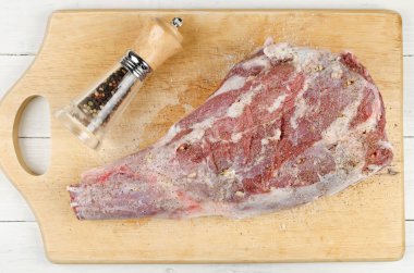 Raw leg of lamb on a cutting board clipart