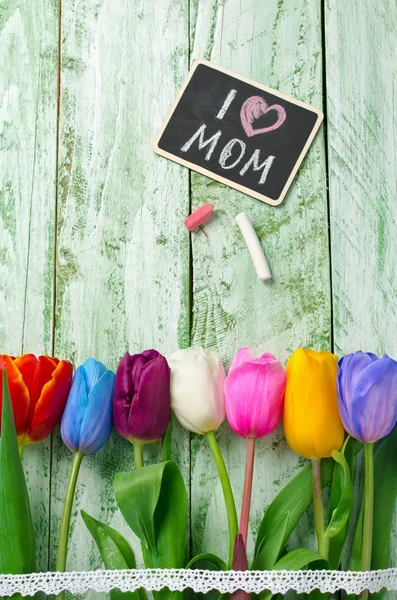 Bunte Tulpen auf einem schäbigen grünen Tisch — Stockfoto