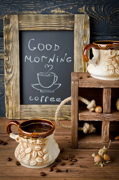 Натюрморт с доской, кофе и грецкими орехами на деревянной доске — стоковое фото