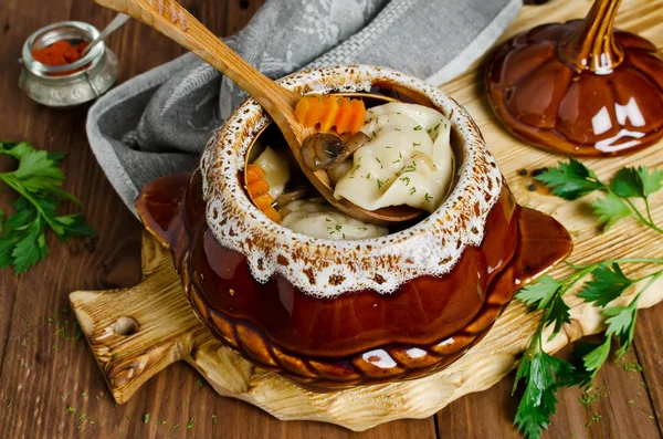 Dumplings en una olla sobre una mesa de madera — Foto de Stock