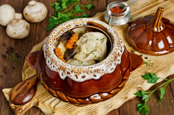 Dumplings in a pot on a wooden table — Stock Photo, Image