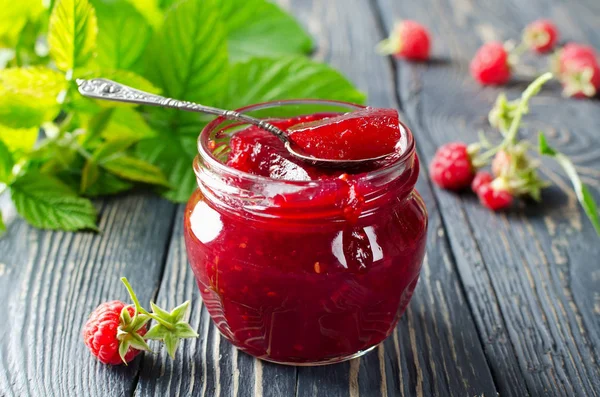 Himbeermarmelade auf einem Holztisch im Garten — Stockfoto