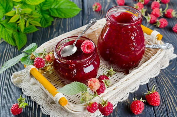 Raspberry jam on a wooden table in the garden — Stock Photo, Image