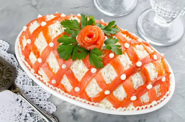 Праздничный салат, украшенный лососем на сером бетоне — стоковое фото