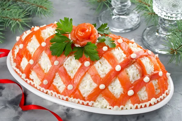 Праздничный салат, украшенный лососем на сером бетоне — стоковое фото
